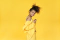 Happy afro girl wear stylish yellow cloth dance isolated on yellow background.