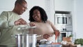 Happy Afro Latin father and daughter preparing lunch together in house kitchen