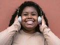 Happy Afro Latin girl having fun listening music with wireless headphones Royalty Free Stock Photo