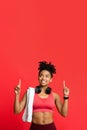 Happy afro sporty girl with towel and earphones pointing up Royalty Free Stock Photo