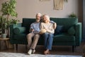 Happy aged couple, wife and husband watching tv and eating popcorn Royalty Free Stock Photo