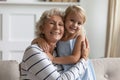 Happy aged grandmother holding little preschool granddaughter in arms