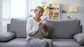 Happy aged woman watching photos on tablet and smiling, spending free time