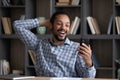 Happy amazed young African American man looking at cellphone screen.