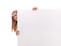 Happy amazed young girl is popping out from the side of white blank banner,isolated
