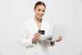 Happy amazing woman posing isolated over white wall background using laptop computer holding credit card Royalty Free Stock Photo