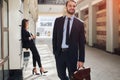 Happy ambitious businessman leaving the office building