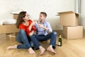 Happy American couple sitting on floor unpacking together celebrating with champagne toast moving in a new house Royalty Free Stock Photo