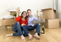 Happy American couple sitting on floor unpacking together celebrating with champagne toast moving in a new house Royalty Free Stock Photo