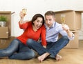 Happy American couple sitting on floor unpacking together celebrating with champagne toast moving in a new house Royalty Free Stock Photo