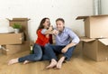 Happy American couple sitting on floor unpacking together celebrating with champagne toast moving in a new house Royalty Free Stock Photo