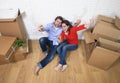 Happy American couple sitting on floor unpacking together celebrating moving to new house flat or apartment Royalty Free Stock Photo