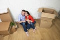 Happy American couple sitting on floor unpacking together celebrating moving to new house flat or apartment Royalty Free Stock Photo