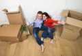 Happy American couple sitting on floor unpacking together celebrating moving to new house flat or apartment Royalty Free Stock Photo