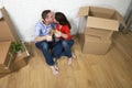 Happy American couple sitting on floor unpacking together celebrating moving to new house flat or apartment Royalty Free Stock Photo