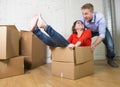 Happy American couple unpacking moving in new house playing with unpacked cardboard boxes Royalty Free Stock Photo