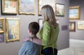 Mother and son looking at paintings in halls of museum Royalty Free Stock Photo