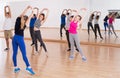 Teenage boys and girls with trainer stretching in dance hall