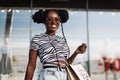 Happy American woman, with shopping bags shopping, fashionable woman enjoying shopping in the city on Black Friday Royalty Free Stock Photo