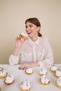 Happy amusing young woman smiling and eating cakes