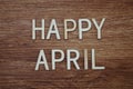 Happy April text message on wooden background