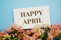 Happy April text with flower frame on blue background