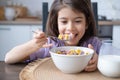 Happy arab child girl having breakfast colorful cereal with milk at home on the morning Royalty Free Stock Photo