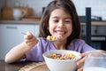 Happy arab child girl having breakfast colorful cereal with milk at home on the morning Royalty Free Stock Photo