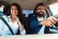 Happy arab couple going on summer vacation by car, smiling man and woman making test drive in the city Royalty Free Stock Photo