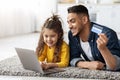 Happy arab dad and daughter with laptop and credit card shopping online Royalty Free Stock Photo