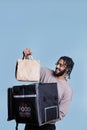 Happy arab deliveryman holding take out paper bag