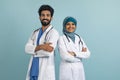 Happy arab doctors man and woman in hijab posing with folded arms, Royalty Free Stock Photo