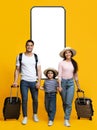 Happy Arab Family Of Three With Suitcases Over Big Phone Royalty Free Stock Photo