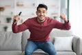 Happy arab guy watching sport on TV at home Royalty Free Stock Photo