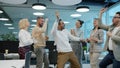 Happy Arab man dancing with multi-ethnic froup of colleagues in shared office