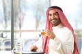 Happy arab man holding a cup of tea looking at camera