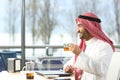 Happy arab man looking away holding a tea cup