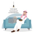 Happy Arab Man relaxing with dried fruit and sitting on blue sofa.