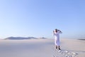 Happy Arab man walks in middle of white desert and enjoys life o