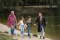 Happy arabian family strolling near lake