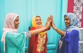 Happy Arabian women stacking hands together outdoor - Young Muslim girls having fun in the university