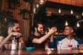 Happy arabian young man giving high five to his friend. Group of mixed race people having fun in lounge bar