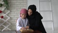 Happy Arabic mother and son together sitting on the couch and reading a book Royalty Free Stock Photo