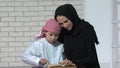 Happy Arabic mother and son together sitting on the couch and reading a book Royalty Free Stock Photo