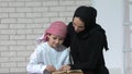 Happy Arabic mother and son together sitting on the couch and reading a book Royalty Free Stock Photo