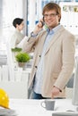 Happy architect at office talking on mobile phone