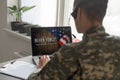 Happy army soldier having video call over laptop