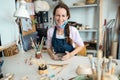 Happy artist woman molding with clay at pottery workshop - Focus on face