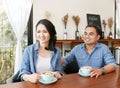 Happy asain couple in blue jean shirt having hot heart shape latte art coffee together Royalty Free Stock Photo