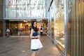 Happy Asia Chinese Eastern oriental young trendy woman girl shopping in mall with bags in front of a store on street Royalty Free Stock Photo